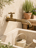 Robinet de jardin Courbe antique, installé sur un mur beige